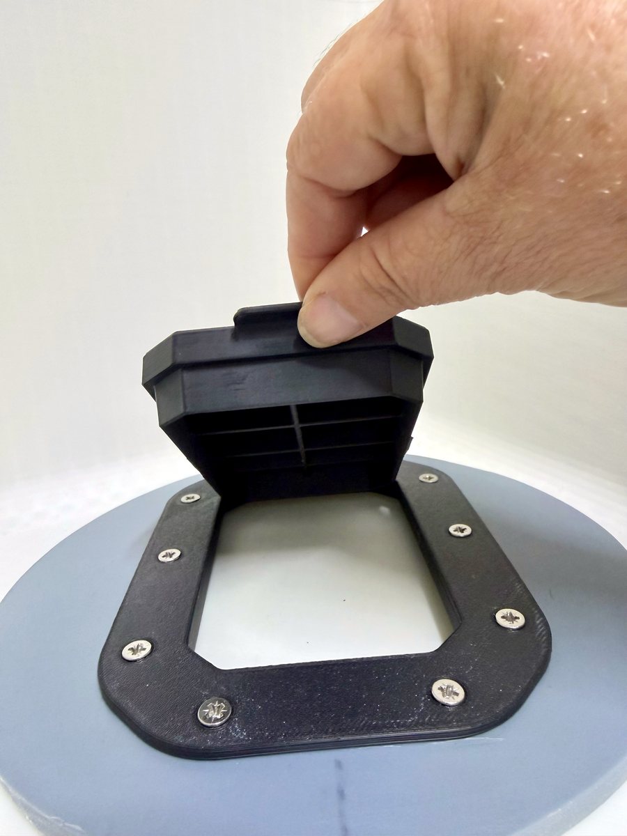 Hand lifting the tab of a Pro Clean-Fit hinged lid to open it